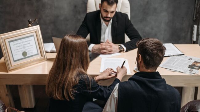A lawyer discusses legal documents with clients in an office setting. - Photo by Pavel Danilyuk on Pexels