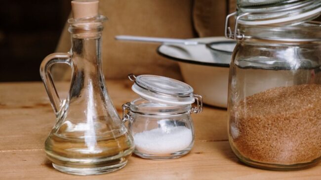 Assorted kitchen ingredients in glass jars on a wooden countertop. - Photo by cottonbro studio on Pexels