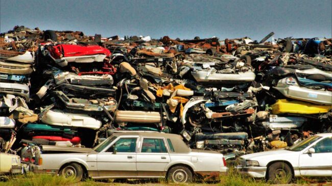 A large stack of disposed vehicles in an outdoor junkyard. - Photo by Benhur Emmanuel on Pexels