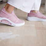 Close-up of fashion-forward pink sneakers worn indoors on a wooden floor. - Photo by Makrufin Muhammad on Pexels
