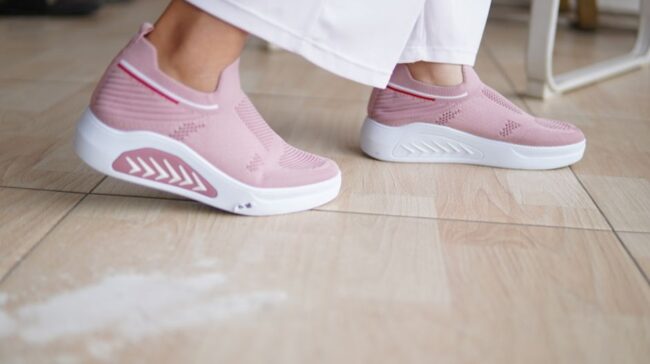 Close-up of fashion-forward pink sneakers worn indoors on a wooden floor. - Photo by Makrufin Muhammad on Pexels