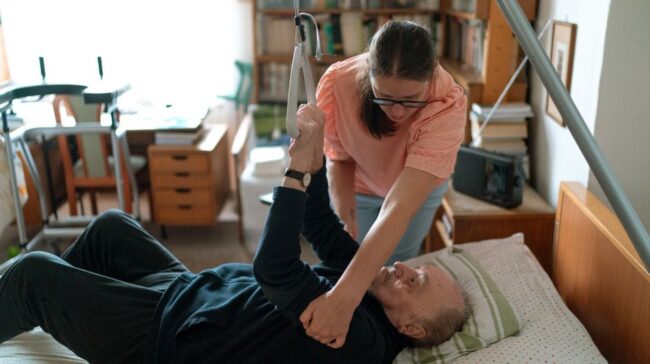 A caregiver assists an elderly man in a home environment, showcasing compassionate home care. - Photo by Jsme MILA on Pexels
