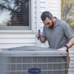 A technician inspects an outdoor HVAC unit for maintenance. - Photo by Kathleen Austin Kuhn on Pexels
