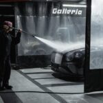 A woman power washing a luxury car in an indoor garage setting, showcasing car wash service. - Photo by Tima Miroshnichenko on Pexels