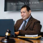 Experienced middle aged ethnic happy male working with netbook at table with judge hammer - Photo by Sora Shimazaki on Pexels